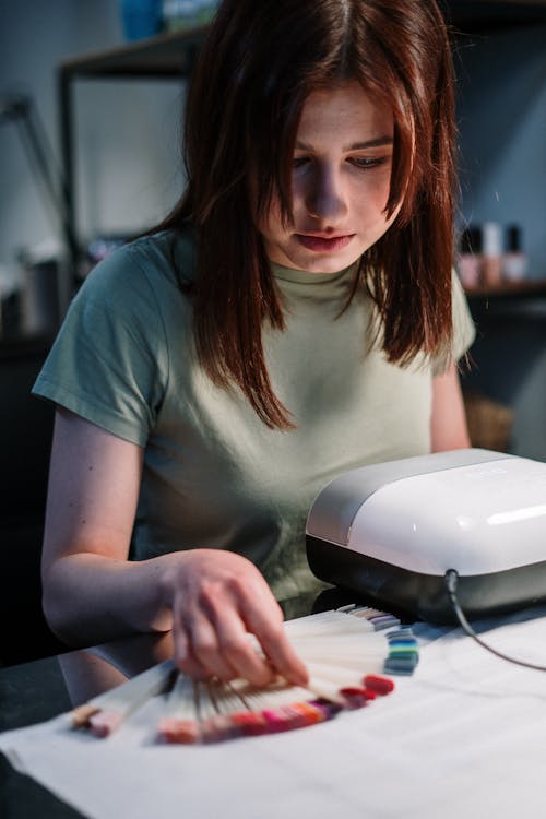 Free Woman in Teal Crew Neck T-shirt Sitting at the Table Stock Photo