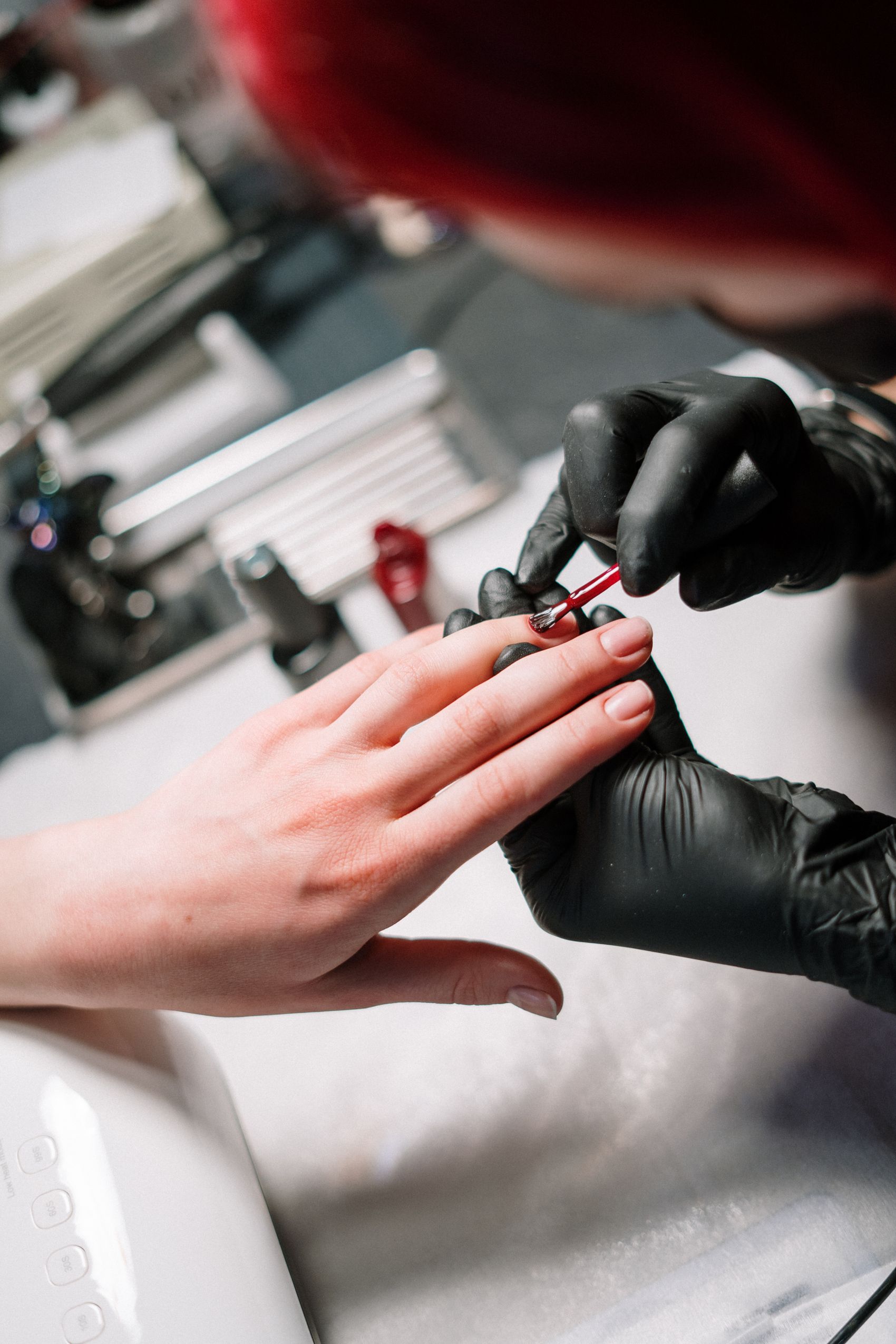 Nail technician painting a glossy manicure at Western Nails & Spa, Calgary NE