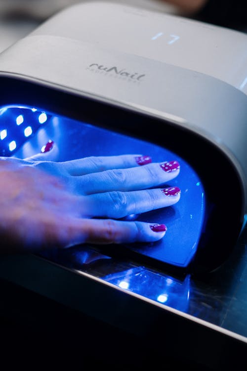 Persons Hand on Blue and White Plastic Container