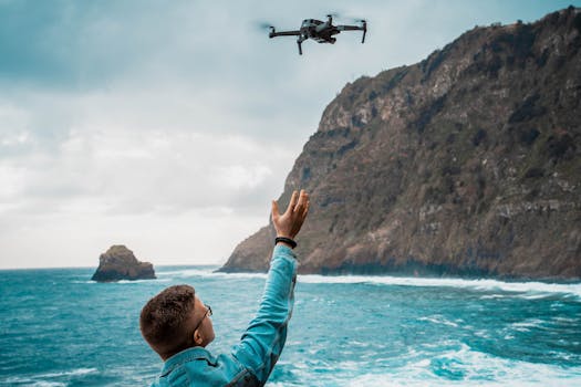 A man launches a drone over Madeira's scenic coastline, capturing ocean views.