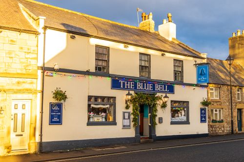 Free Charming view of The Blue Bell pub illuminated by warm sunlight, capturing a quaint English street scene. Stock Photo