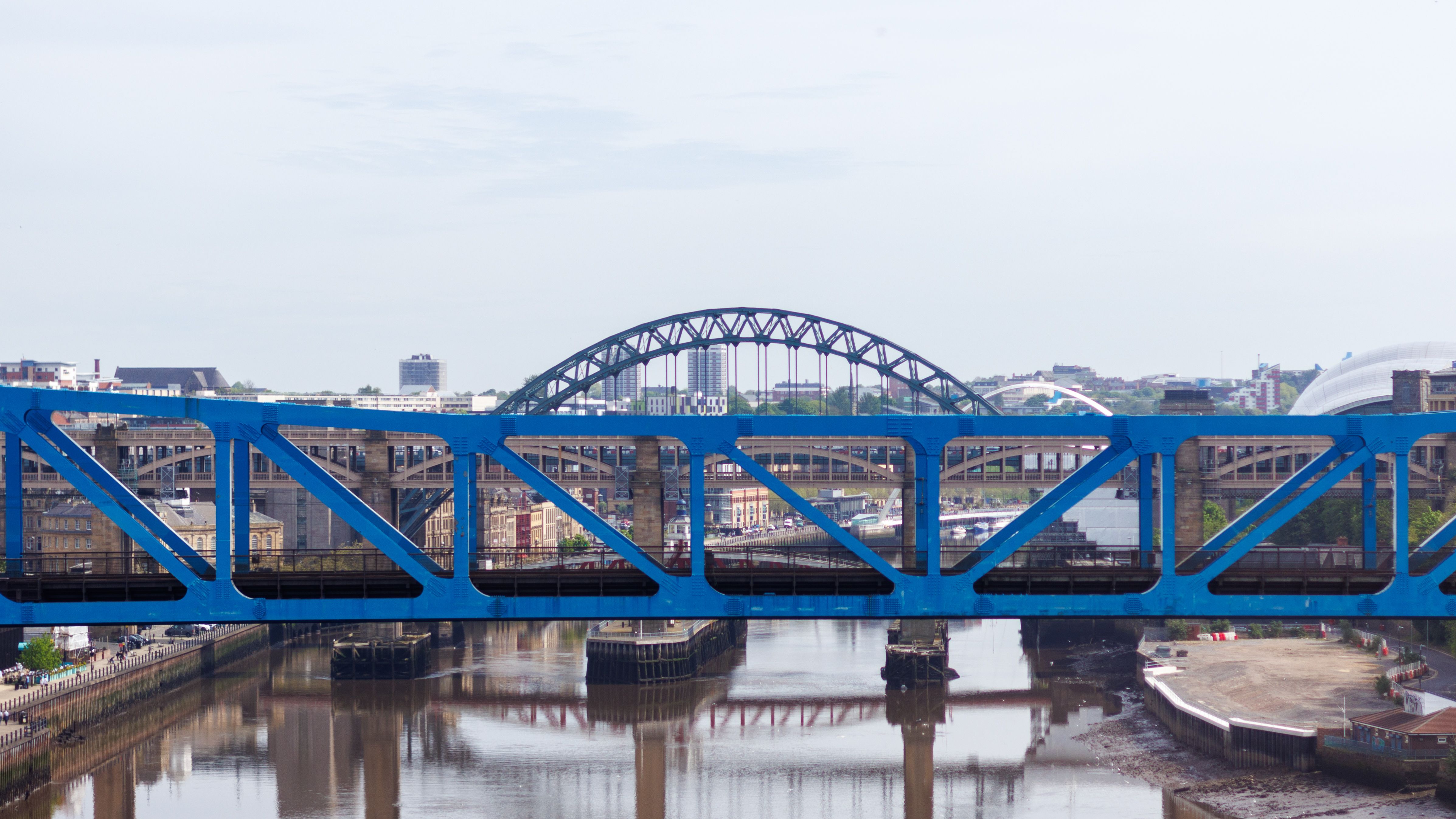 A view of multiple bridges spanning the River Tyne in Newcastle, featuring the iconic Tyne Bridge.