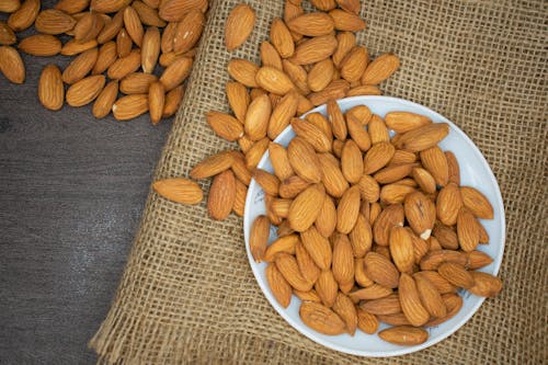 Nueces De Almendra Marrón En La Placa Blanca.