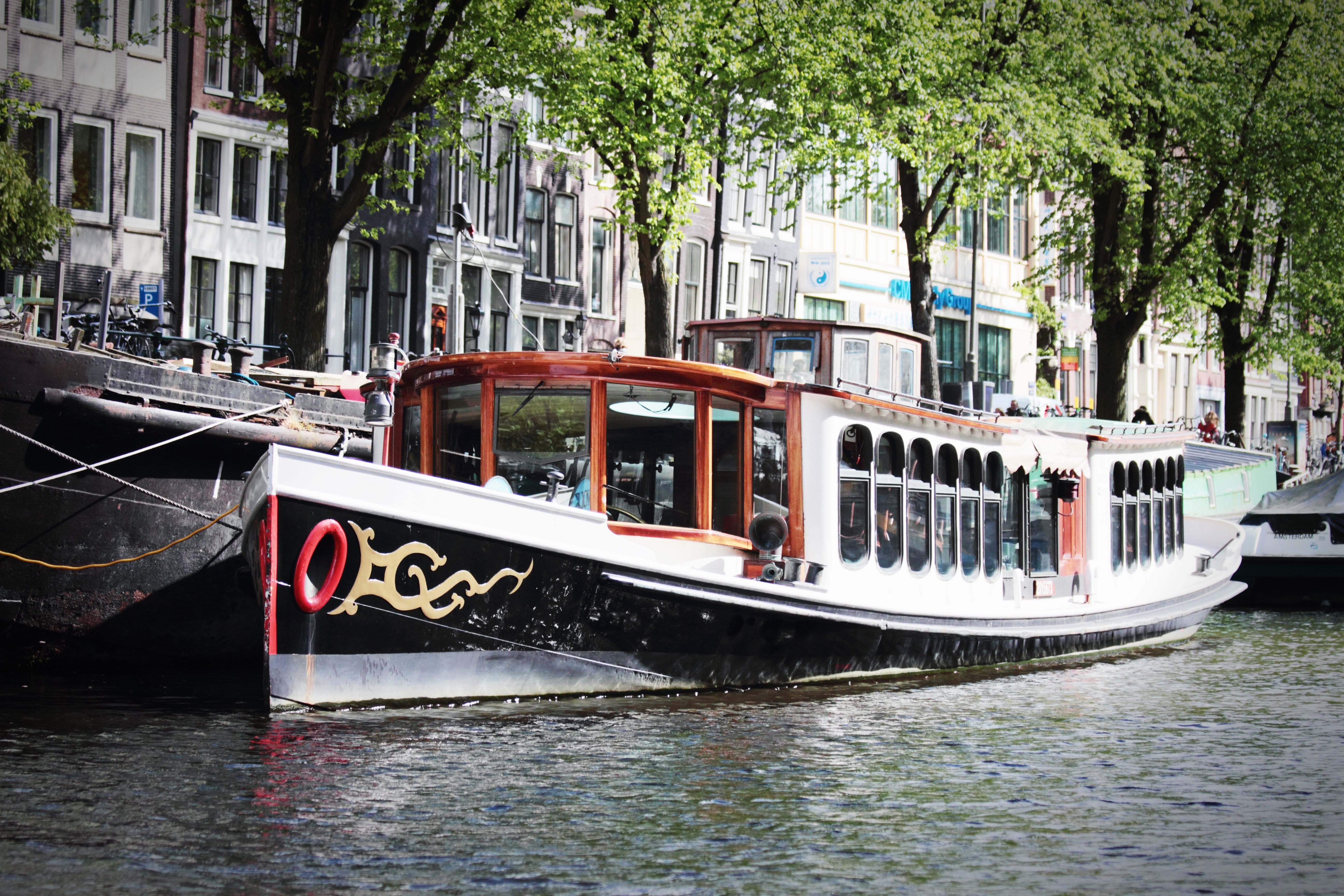 A picturesque canal boat cruising in the iconic waters of Amsterdam, Netherlands.