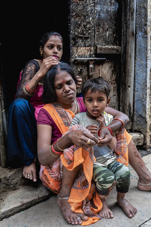 Free A family interacts in an intimate moment on a rustic street in Varanasi. Stock Photo