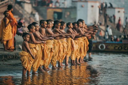 Free A group of young monks in saffron robes performing a religious ritual at the Varanasi Ghats. Stock Photo