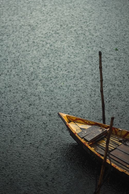 Free A traditional wooden boat moored in water during a rainy day in Narayanganj, Bangladesh. Stock Photo