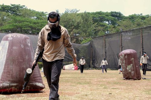 Free Action-packed paintball game with players in protective gear outdoors. Stock Photo