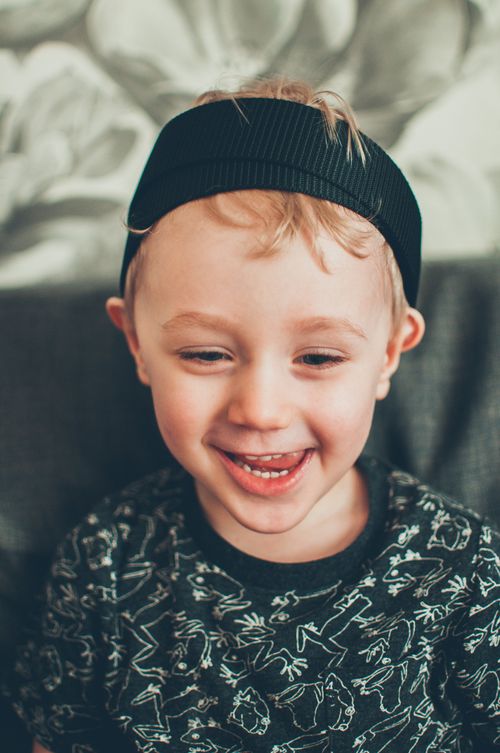 Free Cheerful young boy wearing a black headband, smiling indoors. Stock Photo