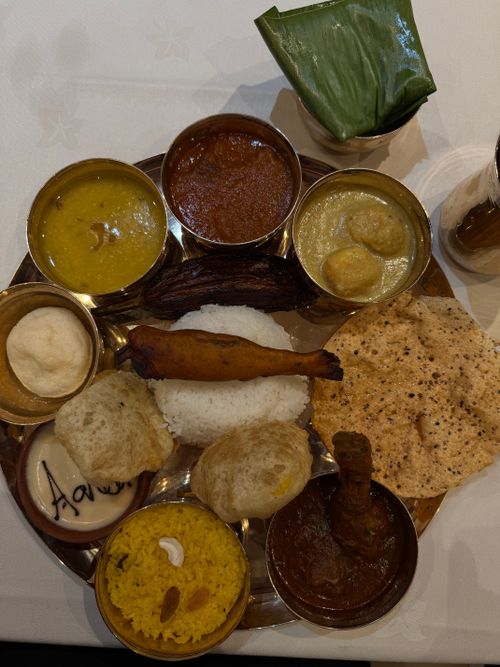 Free A traditional Bengali thali featuring rice, curries, and bread served on a metal plate. Stock Photo