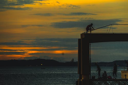 Silhouette of People in a Structure near Body of Water