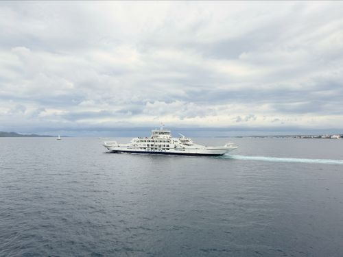 Free A serene view of a ferry cruising in the Adriatic Sea under a cloudy sky near Zadar, Croatia. Stock Photo
