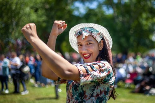 Free Smiling woman enjoying a sunny day in colorful attire, capturing vibrant outdoor joy. Stock Photo
