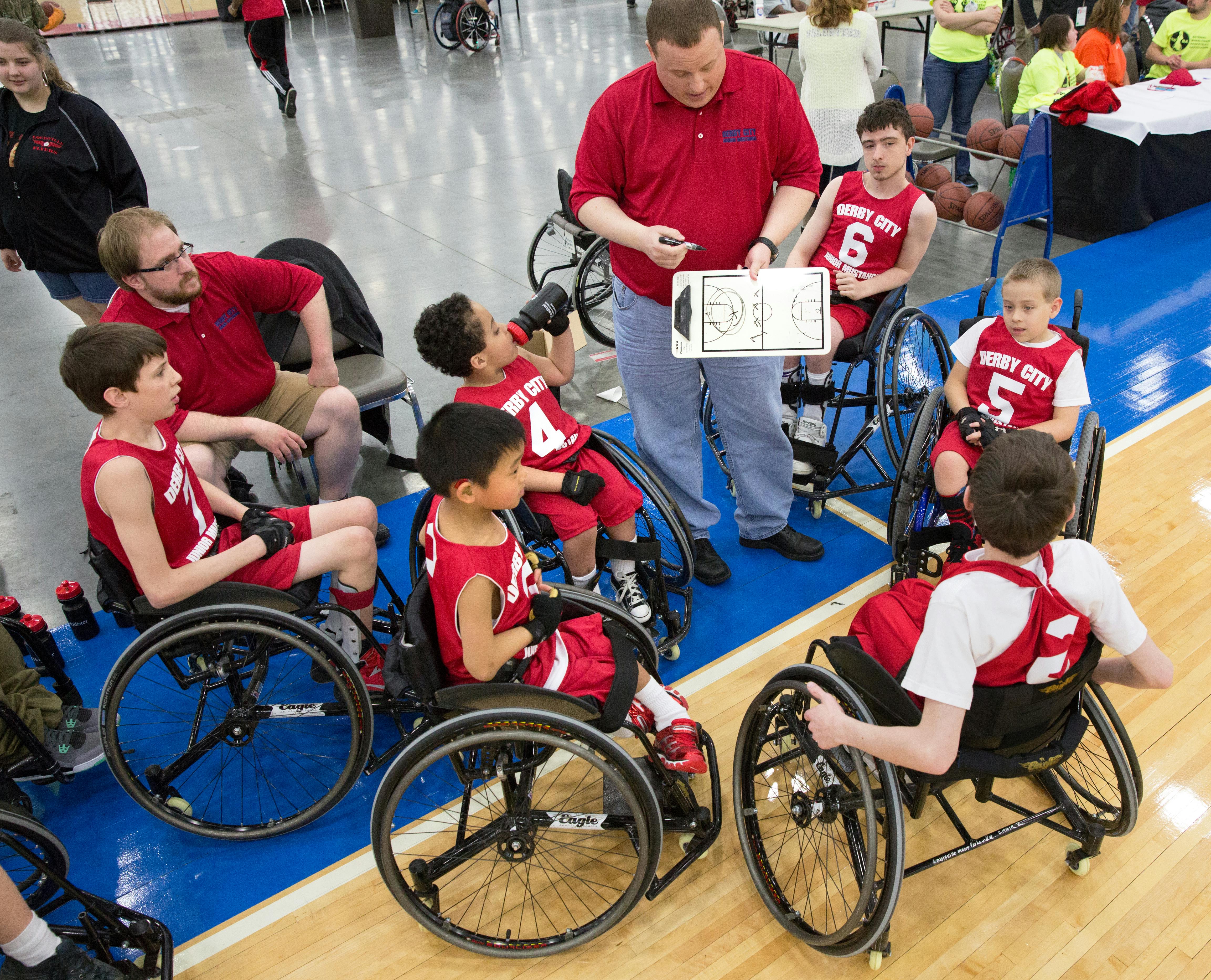 group of children sitting on wheelchair wearing basketball uniforms