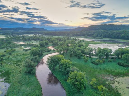 Free Picturesque aerial view of a river winding through lush green fields at dawn in Tell, Wisconsin. Stock Photo
