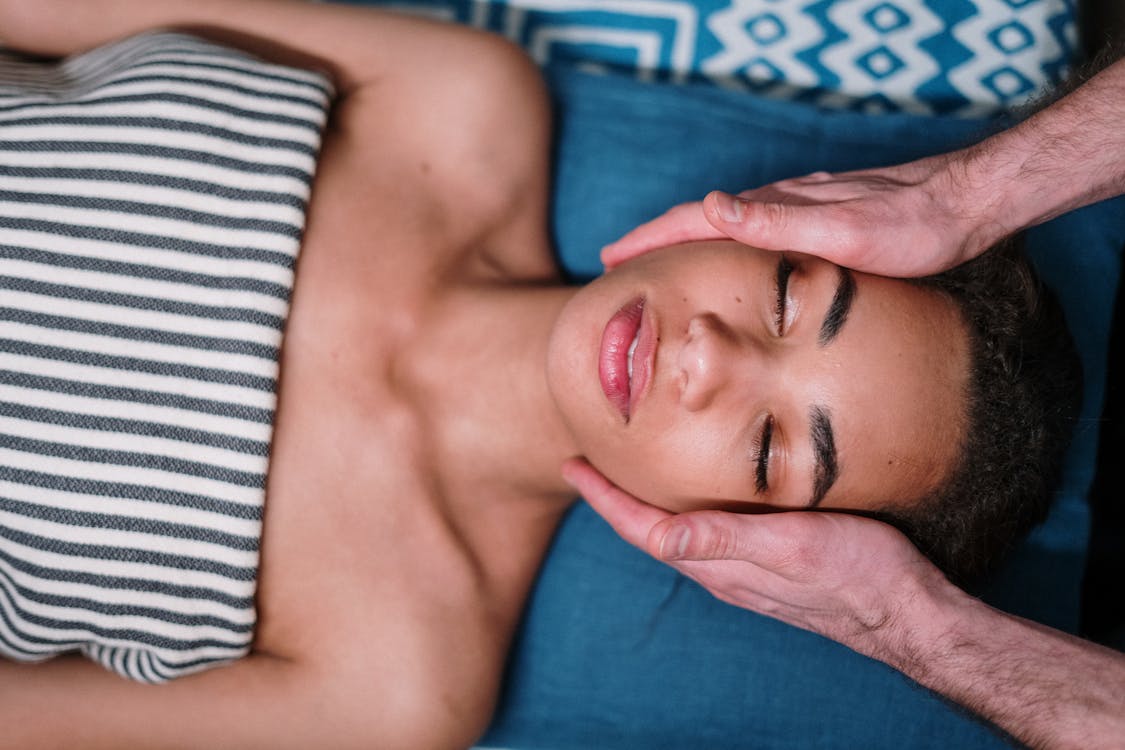 Free Woman Lying on Blue Textile Stock Photo benefits of facials