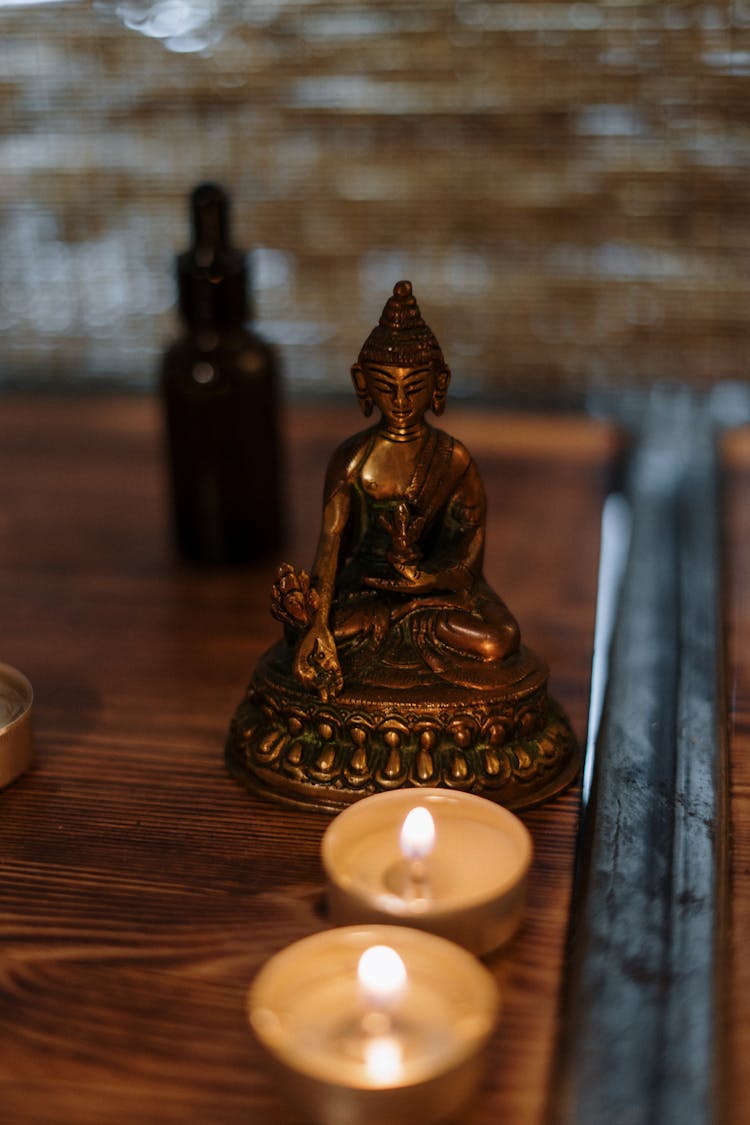 Gold Buddha Figurine On Brown Wooden Table