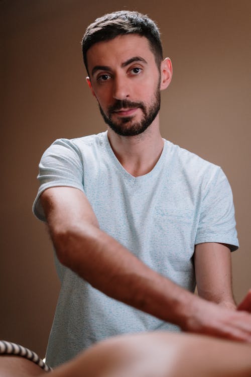 Man in White Crew Neck T-shirt Offering a Massage