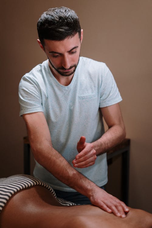 Free Man in White Crew Neck T-shirt Sitting on Chair Stock Photo