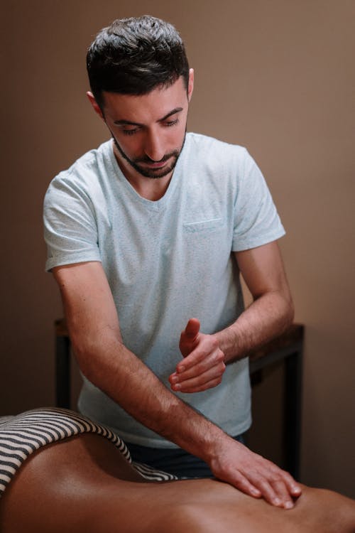 Man in White Crew Neck T-shirt Sitting on Chair