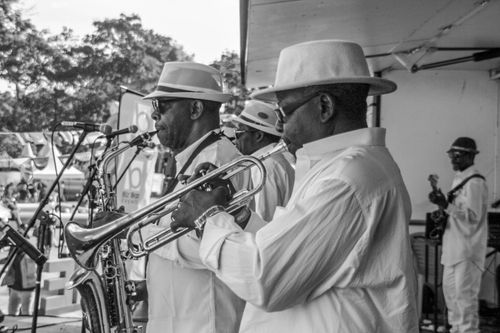 Free A jazz band plays outdoors, featuring saxophone and trumpet players in stylish hats. Stock Photo