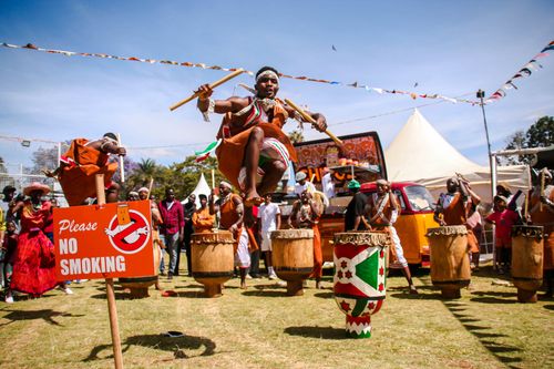 Free Traditional African dancers in colorful attire perform exuberantly at an outdoor event. Stock Photo