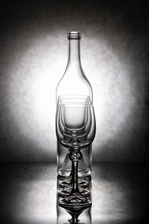 Free Artistic photo of wine glasses and bottle in a striking arrangement against subtle background. Stock Photo