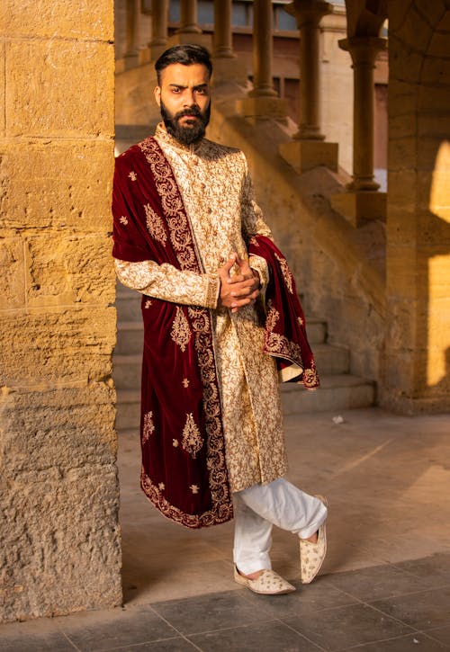 Man in Red and Golden Marriage Dress Gray Concrete Floor