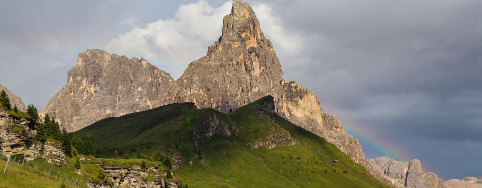 Stunning view of Dolomites' peaks with a rainbow in Trentino-Alto Adige, Italy.