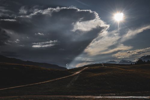 Free Scenic view of the Alps in Trentino-Alto Adige with dramatic clouds and sunrays. Stock Photo