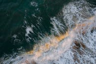 令人惊叹的航拍视角，海浪拍打海岸，带有戏剧性的泡沫和运动