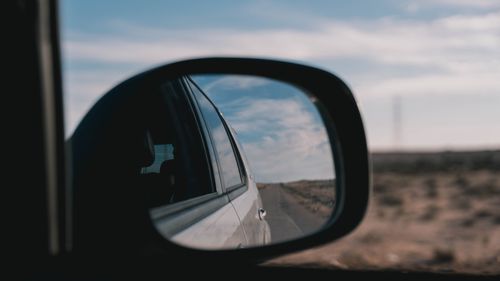 Free A desert road reflects in a car's side mirror, capturing the journey through the Libyan landscape. Stock Photo
