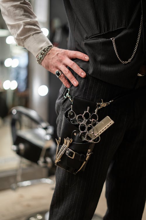 Person in Black Long Sleeve Shirt Holding Gold and Silver Beaded Bracelet