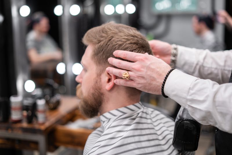 Barber giving a client a fresh fade haircut