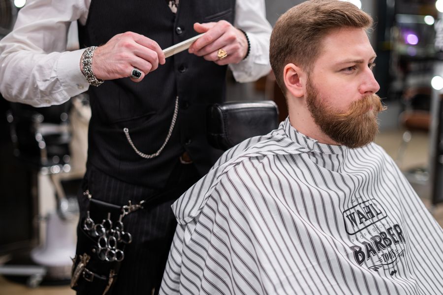 A barber combing a seated customer's hair