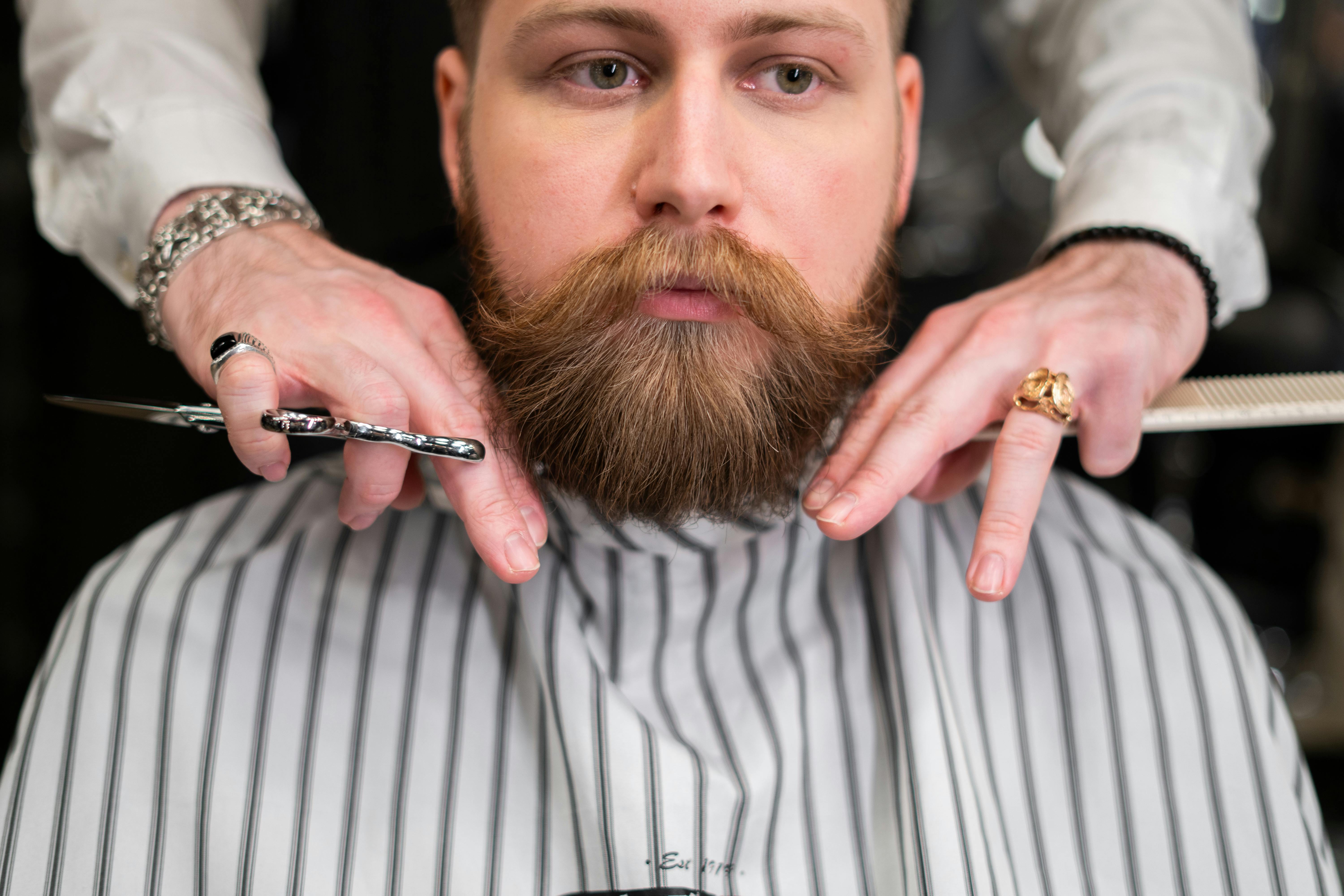 Grooming professional trimming and shaping a client’s beard during an appointment in Los Angeles.