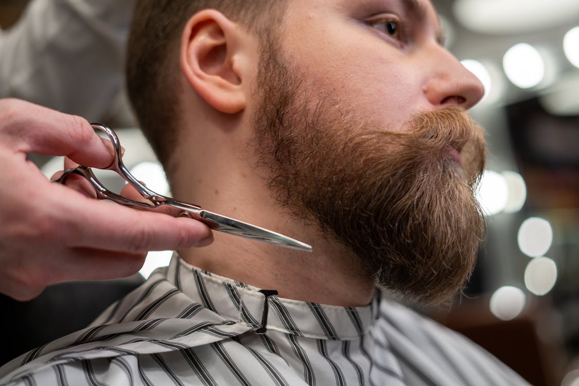 Barbero hombre barbudo con tijeras: fotografía de stock