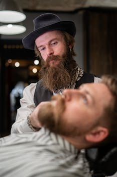A focused barber trims a client's beard in a stylish barbershop.