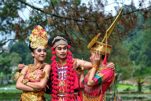 Free Three people in vibrant Sundanese traditional costumes posing outdoors in Bandung, Indonesia. Stock Photo