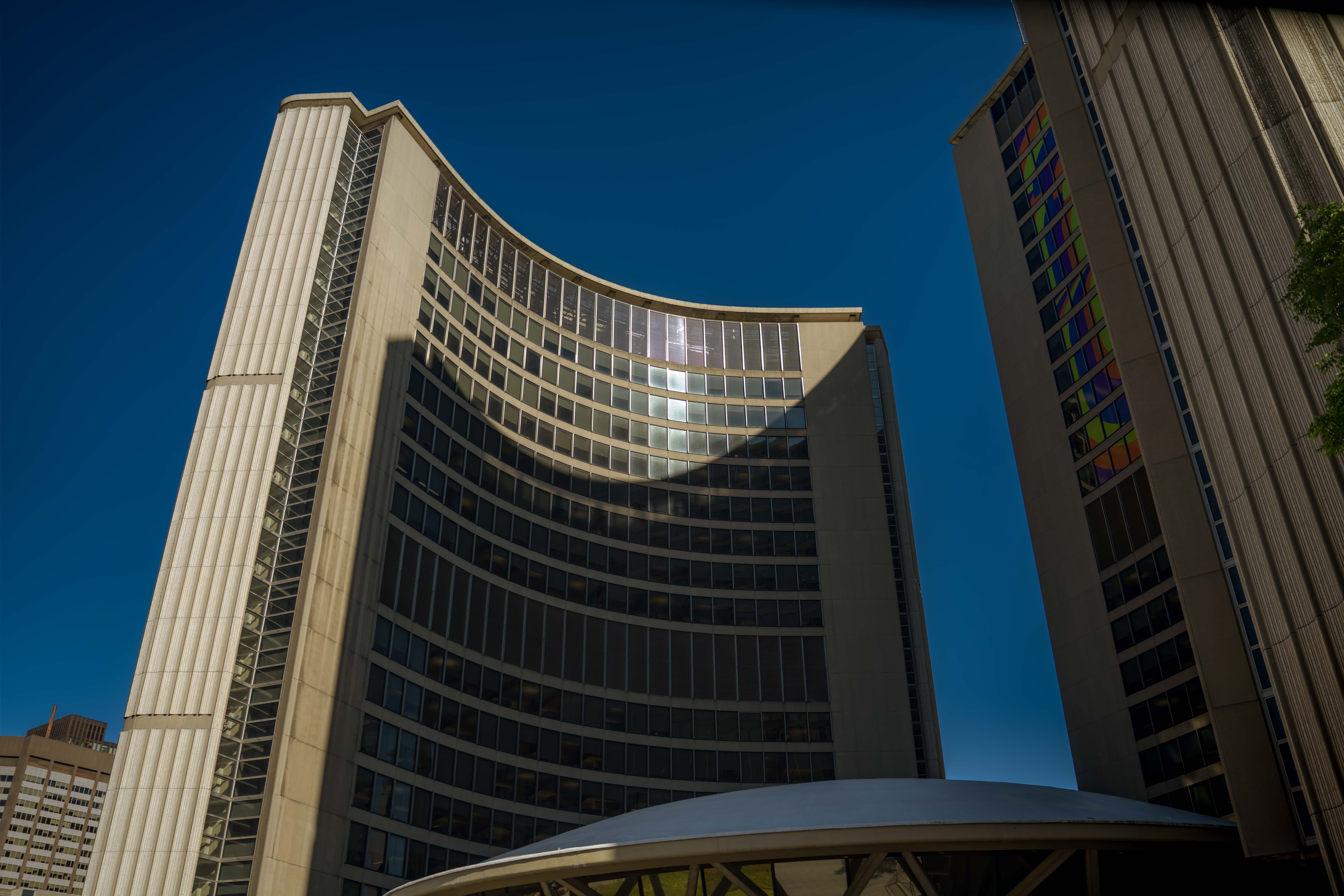 Stunning view of the curved facade of Toronto City Hall under a clear blue sky.