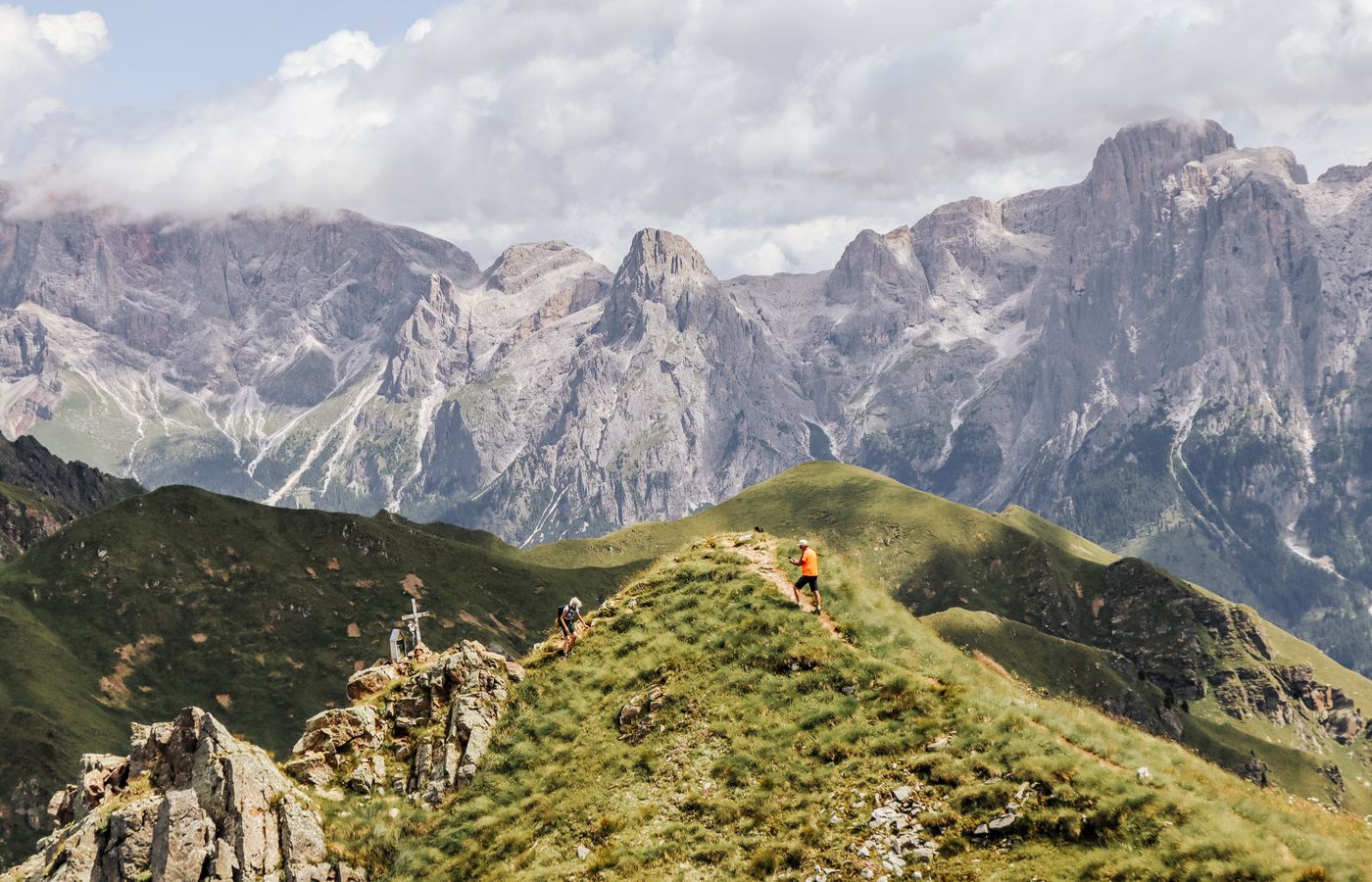 Explore the stunning landscape of the Dolomites with hikers on a scenic ridge trail.