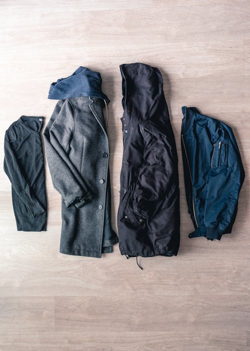 Flat Lay Of Jackets On Brown Wooden Floor