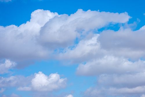 Free Serene image of a clear blue sky with fluffy clouds, perfect for backgrounds or nature themes. Stock Photo