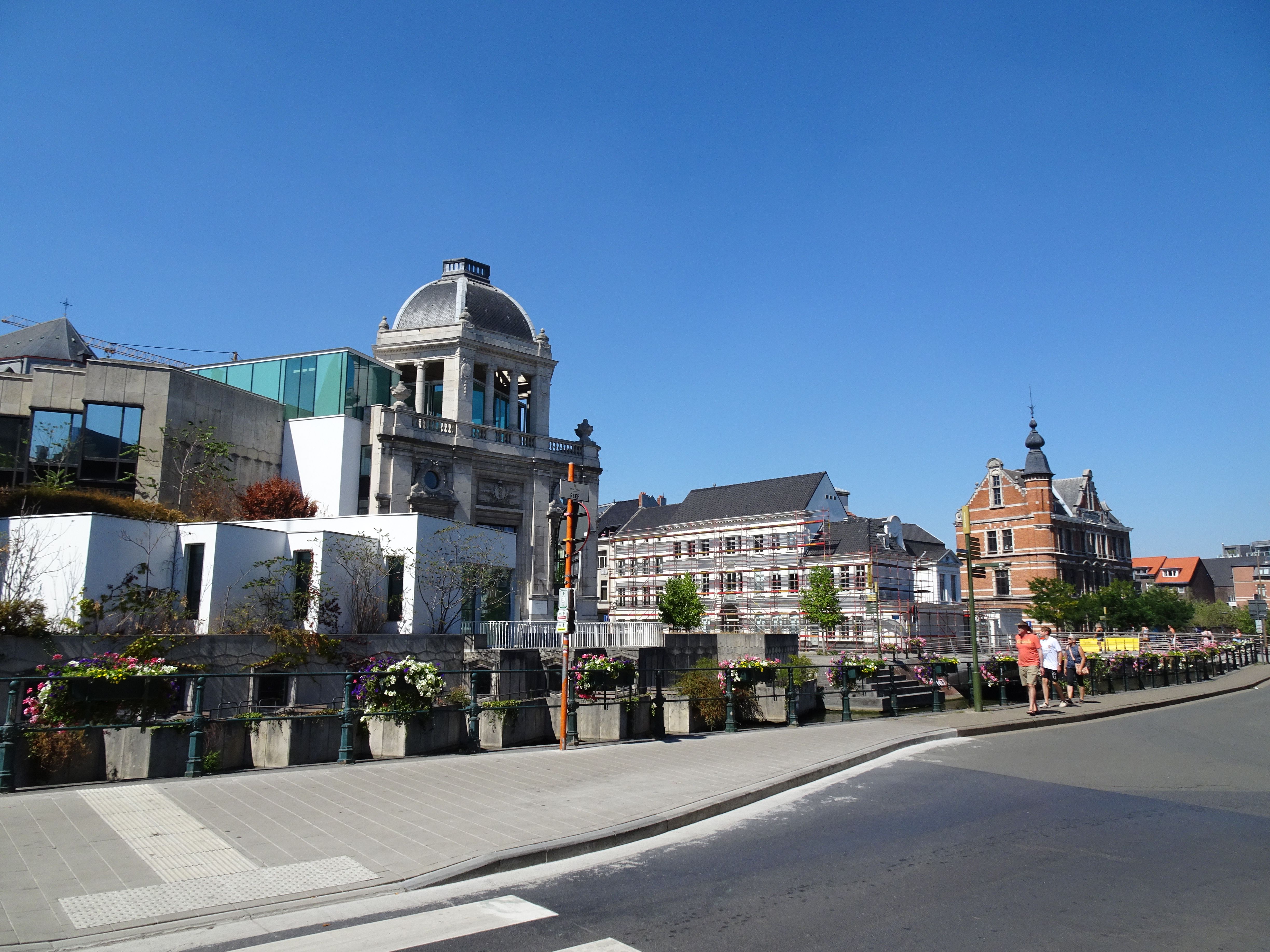 Explore the charming architecture of Ghent, Belgium with historic buildings along a sunny street.