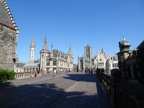 Scenic view of medieval architecture on a sunny day in Ghent, Belgium, showcasing historic landmarks and cobblestone streets.