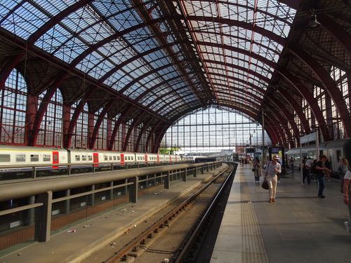 Free Capture of Antwerp Central Station with travelers and trains, showcasing its grand architecture. Stock Photo