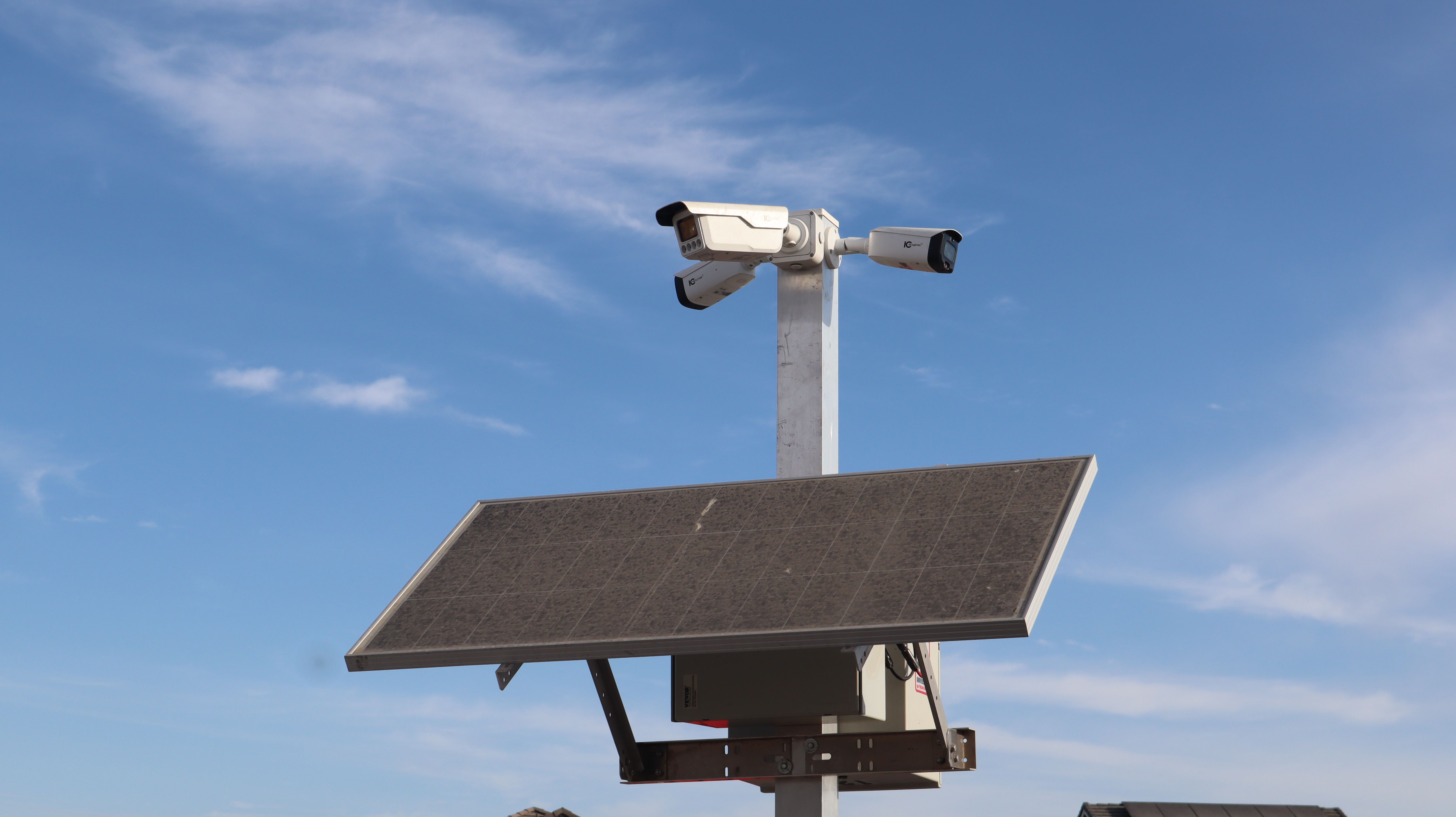 wireless camera with a small solar panel mounted on a sunny corner of a suburban house