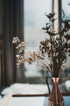铜花瓶里优雅地摆放着迷人的干花，背景柔和