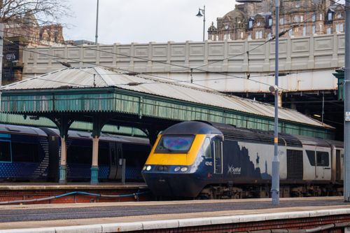 Free A Scotrail train captured at a historic station in Edinburgh, Scotland showcasing classic architecture. Stock Photo