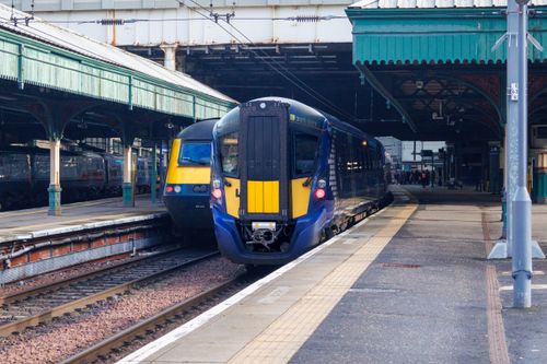 Free A scenic view of trains at a historic railway station in Scotland, showcasing modern transportation. Stock Photo